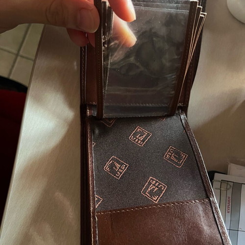 Brown wallet used with multiple card slots and belt-style clasp