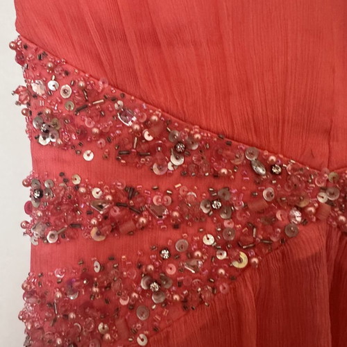 Coral short evening dress with crisscross straps, V neckline, and shiny embroidered beads