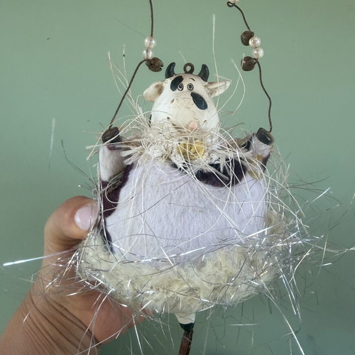 Hanging decorative ornament with fabric and ceramic cow