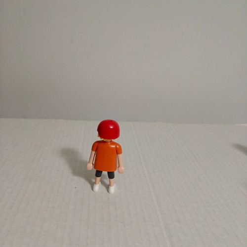 Playmobil figure with orange-red shirt and helmet used