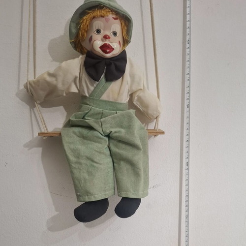 Porcelain clown doll on wooden swing, vintage collectible