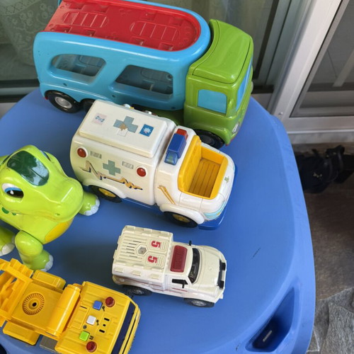 Various toys including vehicles and dinosaur