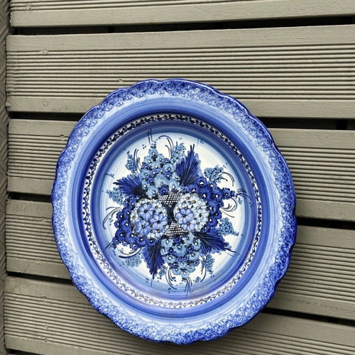 Handmade ceramic wall plate used with blue floral motif