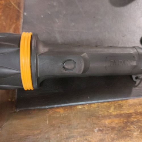 Handheld flashlight used, black with yellow