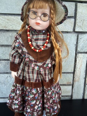 Vintage porcelain doll with brown dress and straw hat like new