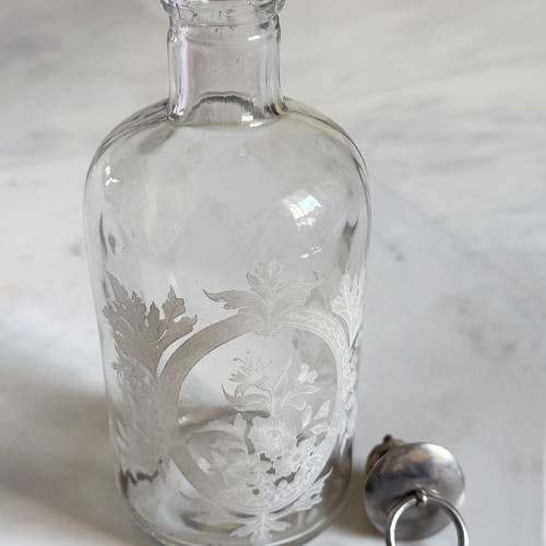 Glass apothecary bottle used with etched floral design