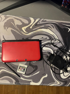 Nintendo 3DS XL console with Luigi's Mansion 2 and charger