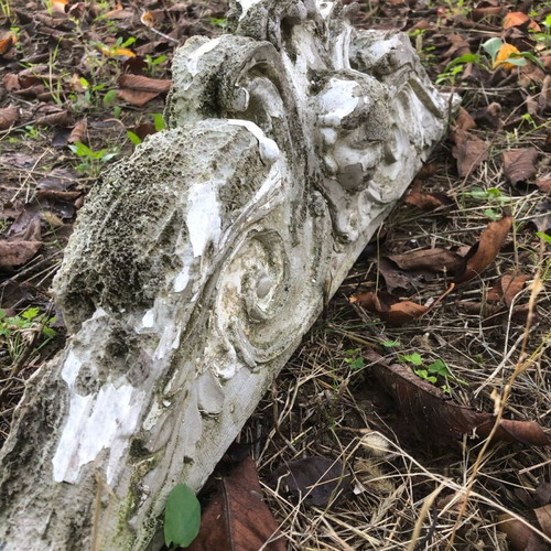 Old plaster pediment used with spiral motifs and human head