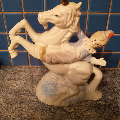 Vintage ceramic clown figurine riding a unicorn used