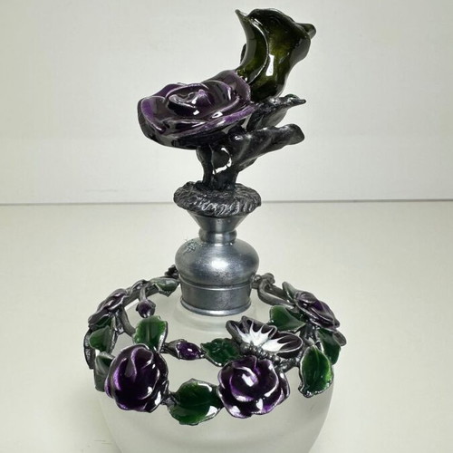 Vintage ornate perfume bottle with frosted glass and metal floral decoration