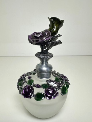 Vintage ornate perfume bottle with frosted glass and metal floral decoration