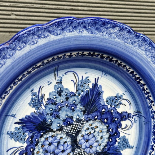 Handmade ceramic wall plate used with blue floral motif