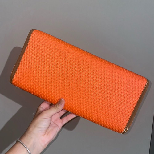 Orange hand clutch bag used with light wear