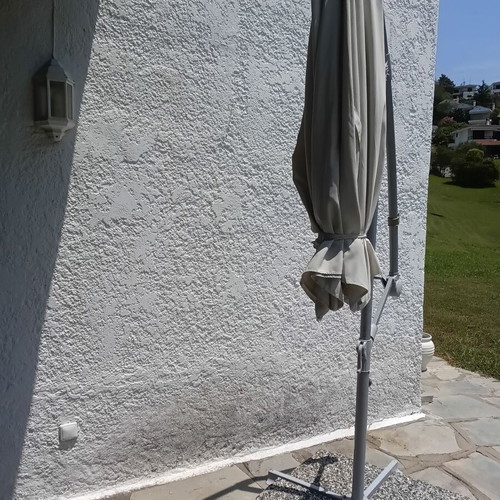 Garden umbrella used, white fabric with support plates