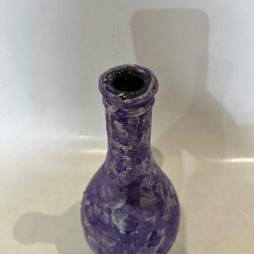 Vintage decorative glass vase covered with lilac rope, used