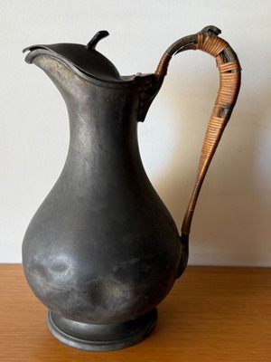 Vintage metal pitcher with woven rattan handle