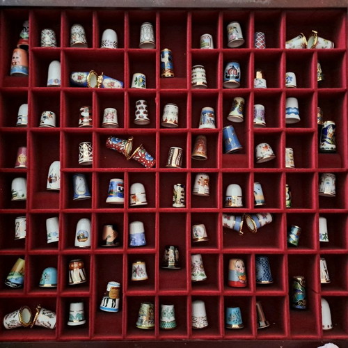 Porcelain thimble collection with wooden display case and book