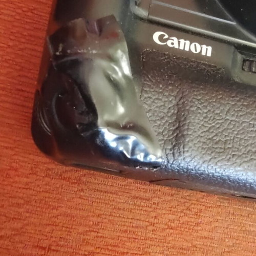 Canon EOS 400D camera used with grip, charger, and two batteries