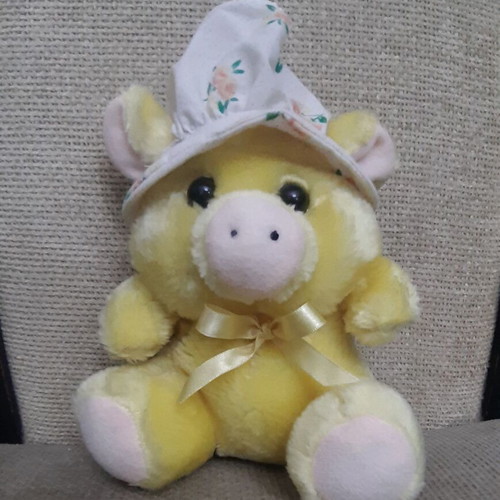 Yellow plush piglet with fabric hat and bow