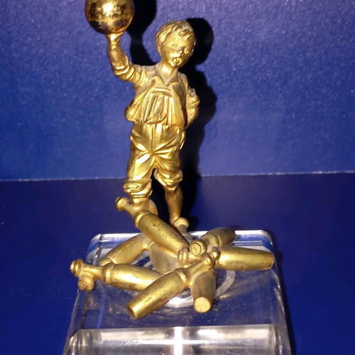 Sculpture of child playing bowling used, bronze with glass base
