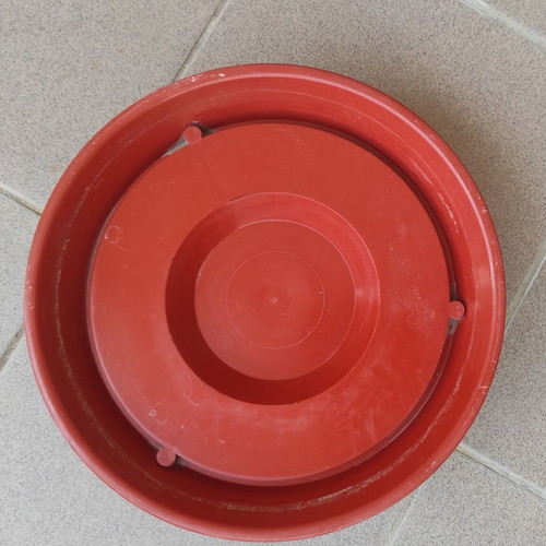 Large plastic flowerpot with saucer and metal balcony railing holder