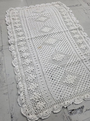 Knitted white handmade table linen with grape design, used