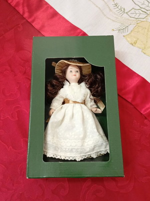Porcelain dolls like new, set of 9 with two furniture pieces