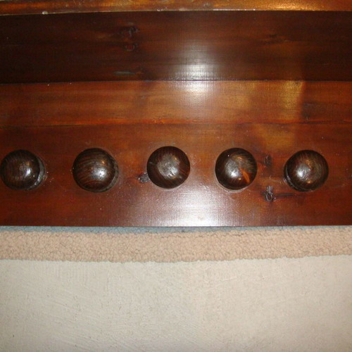 Wooden wall-mounted hat rack with seven hooks used