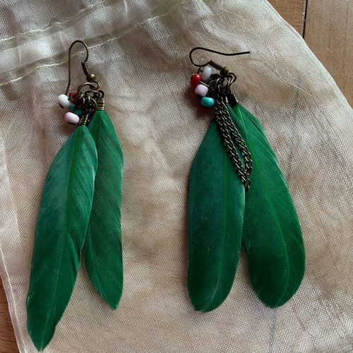Handmade earrings used with green feathers and multicolored beads