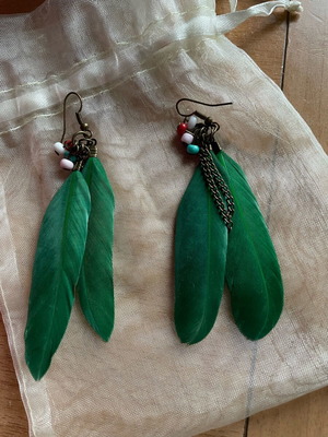 Handmade earrings used with green feathers and multicolored beads