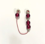 Small worry beads used with red translucent beads and metal details