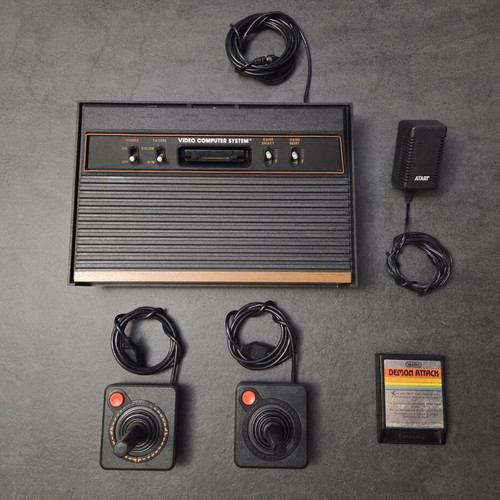 Atari 2600 VCS Woody console used with two joysticks and Demon Attack game