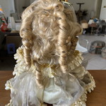 Porcelain doll sitting with curls, vintage