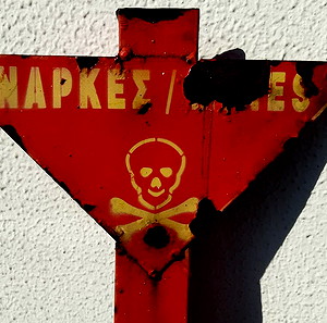 Προειδοποιητική πινακίδα ναρκοπέδιου (πραγματική από αποναρκοθετημένη περιοχή του Γράμμου)