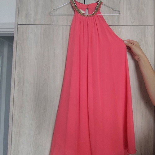 Coral dress with a jewel tie at the neck