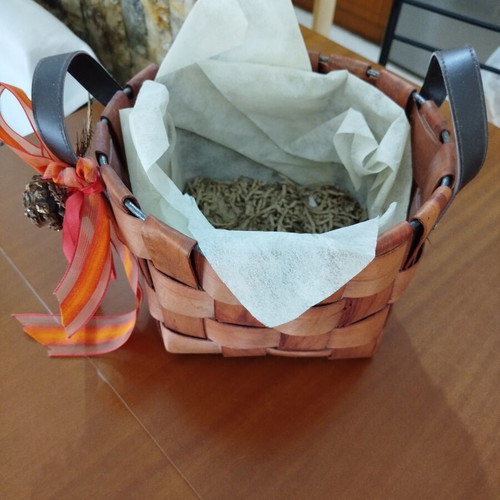 Wooden woven gift basket with leather handles, used