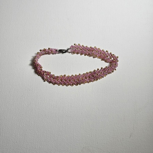 Handmade bracelet with pink beads and gold details used