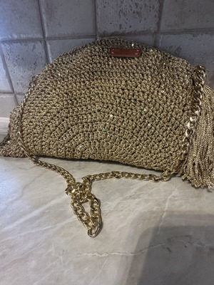 Handmade knitted shoulder bag in gold with decorative tassel