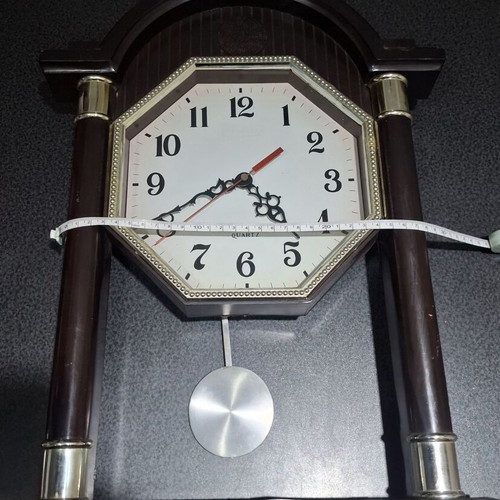 Quartz wall clock with pendulum used, faux wood plastic