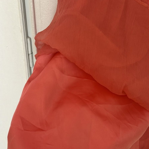 Coral short evening dress with crisscross straps, V neckline, and shiny embroidered beads