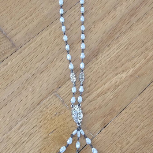 Necklace used with drop-shaped pearls and silver metal details