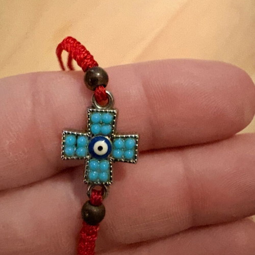 Red bracelet with cross and evil eye charm