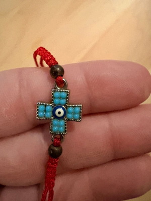 Red bracelet with cross and evil eye charm