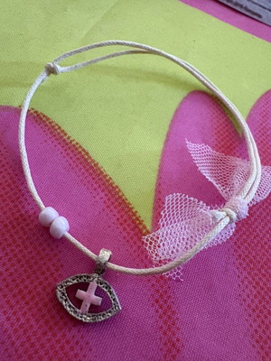 Adjustable cord bracelet with metal eye and pink cross