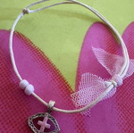Adjustable cord bracelet with metal eye and pink cross