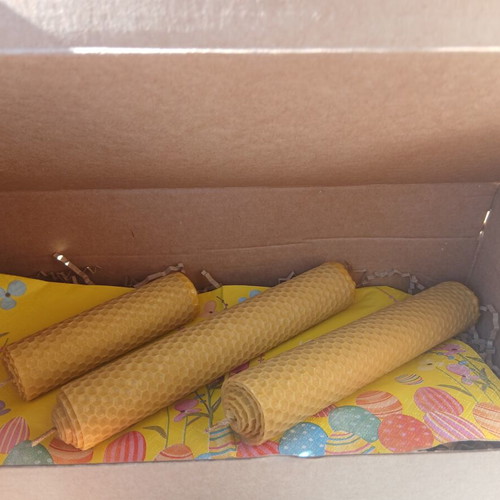 Handmade beeswax candles in decorative box with herbs and oils
