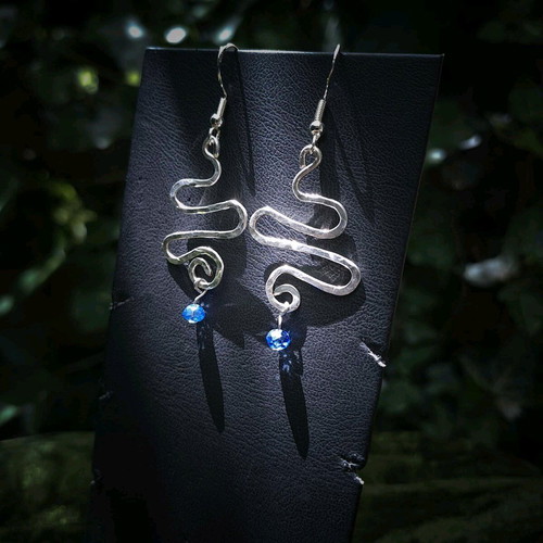 Swirly silver earrings with light blue crystal new