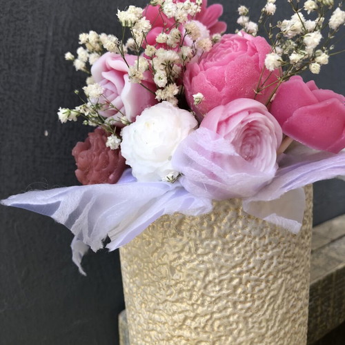 Flower arrangement with scented candles in plaster vase