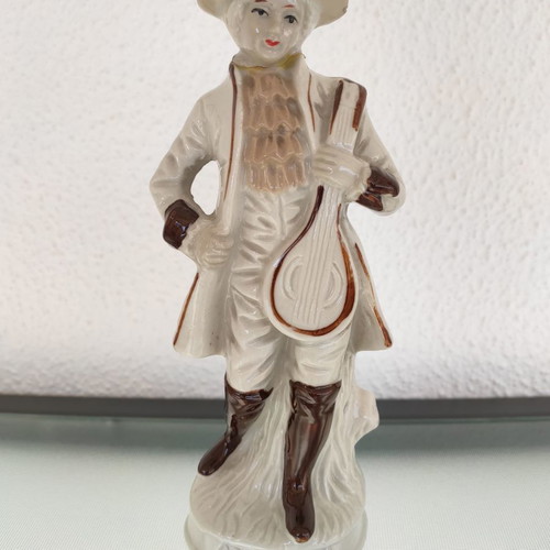 Porcelain decorative figure of man used with musical instrument