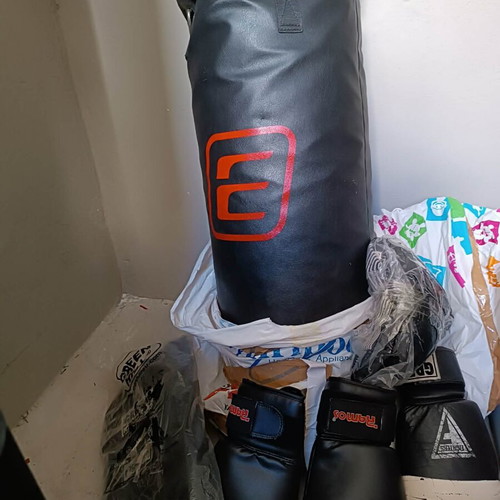 Boxing bag with gloves, hand wraps and knee pads used